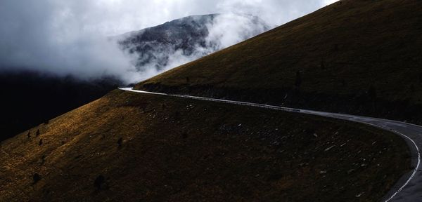 View of mountain road against cloudy sky