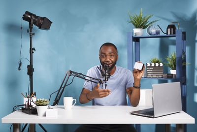 Portrait of senior man using mobile phone while sitting on table