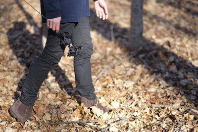 Low section of man standing on ground during autumn