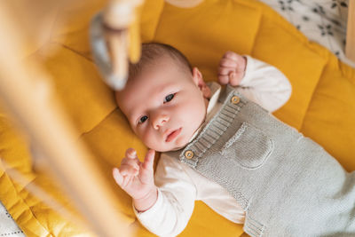 Portrait of cute baby lying on bed