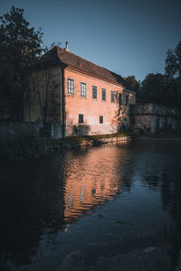 Building by lake against sky