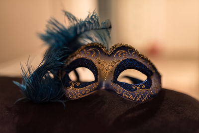 Close-up of feather mask on table