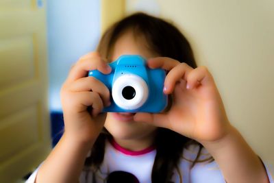 Portrait of cute girl holding camera