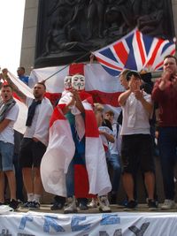 Group of people with arms outstretched standing outdoors