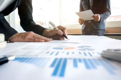 Low section of man holding paper