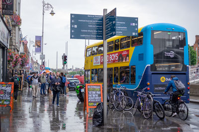 People on wet street in city during rainy season