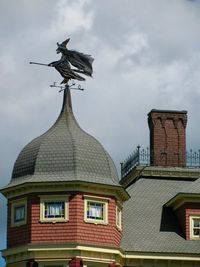 Low angle view of statue against building against sky