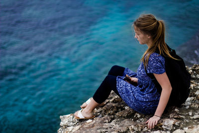 Young woman in front of sea on sunny day