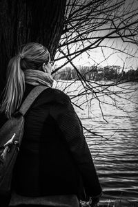 Rear view of woman by lake during winter