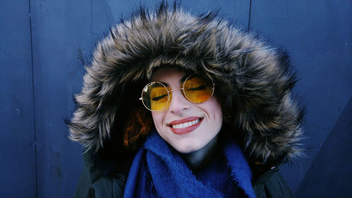 Close-up of young woman in fur coat and sunglasses