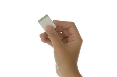 Close-up of hand holding guitar against white background