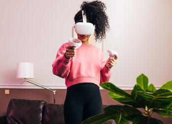 Midsection of woman wearing virtaul reality headset at home