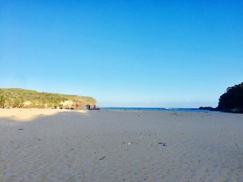 Scenic view of beach against clear blue sky