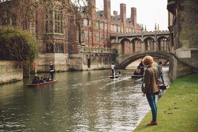 Woman standing by river at cambridge university