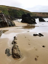 Rocks on beach against sky