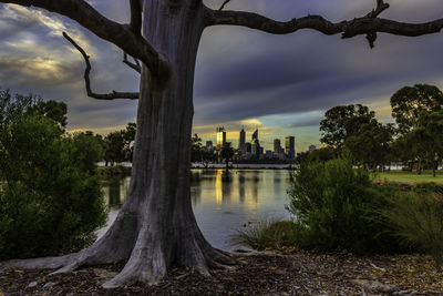 River passing through city against cloudy sky