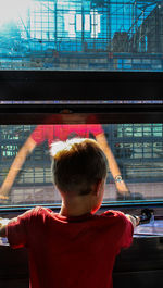 Rear view of boy looking at railroad station