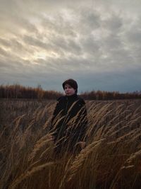 Woman standing on field against sky