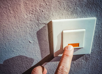 Person holding umbrella against wall