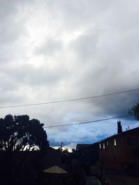 Low angle view of birds against cloudy sky