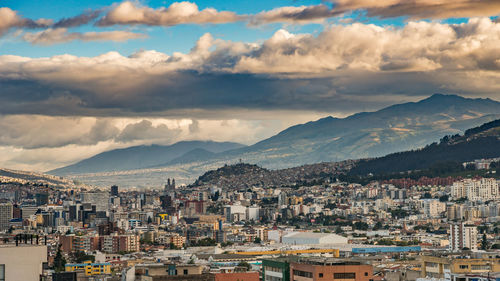 Cityscape against cloudy sky during sunset