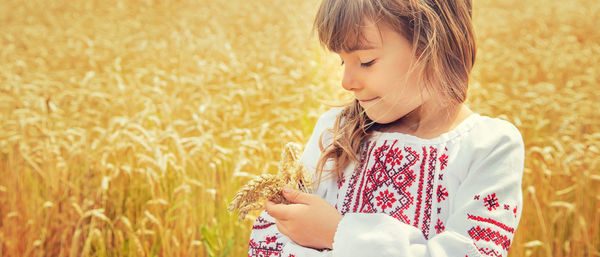 Close-up of young woman holding wheat