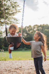 Full length of siblings playing at park