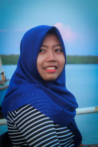 Portrait of smiling man standing against blue sea