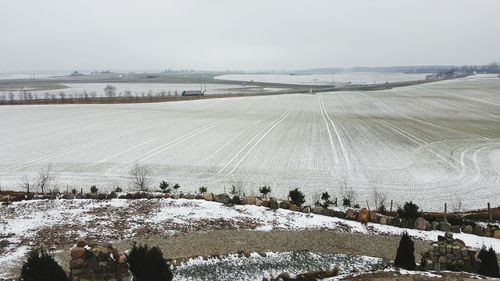 Scenic view of snow covered land against sky