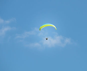 Low angle view of parachute against blue sky