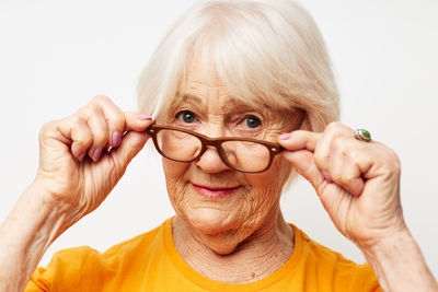 Portrait of young woman with eyes closed against white background