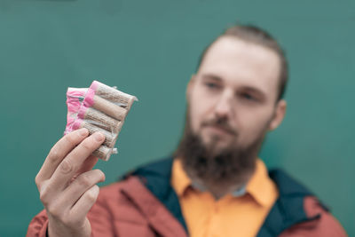 Close-up portrait of young man holding camera