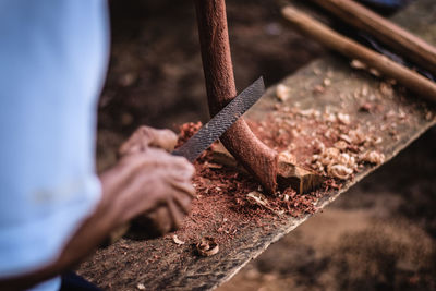 Midsection of worker shaving wood