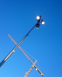 Low angle view of crane against clear sky