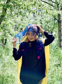 Portrait of young woman standing in park