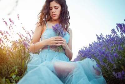 A beautiful young girl against the sunset and a beautiful sky in a lavender field. 