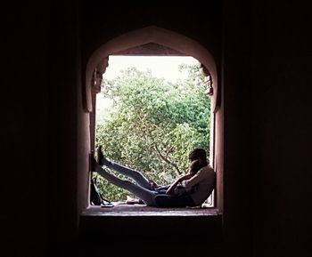 Silhouette of man sitting in window