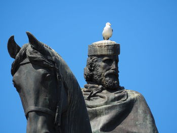 Low angle view of statue against clear blue sky