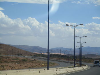 Street by mountain against sky