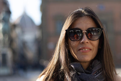Portrait of woman smiling with sunglasses unfocused background at florence, italy. 50mm lens