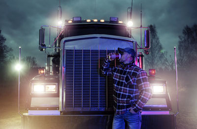 Rear view of man standing by car