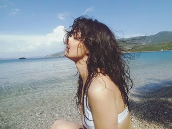 Woman at beach against sky