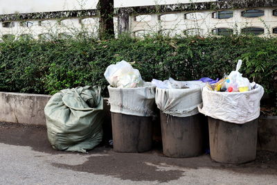 Garbage bin on street against trees