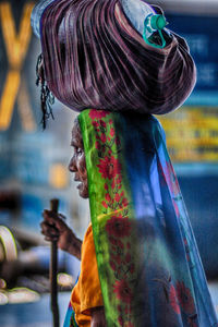 Midsection of man with multi colored umbrella