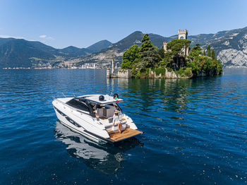 Boat moored on sea against blue sky