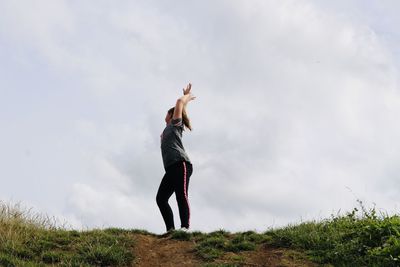 Full length of woman standing on field against sky