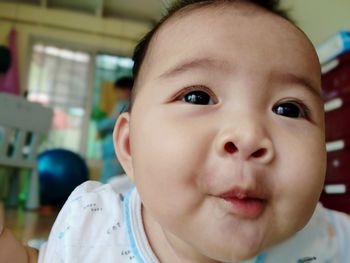 Close-up of cute baby girl at home