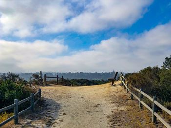 Hiking walkway path with bench with foliage and blue sky in encinitas in san diego, california