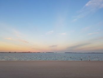 Scenic view of beach against sky at sunset