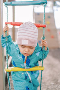 Portrait of cute boy swinging at playground